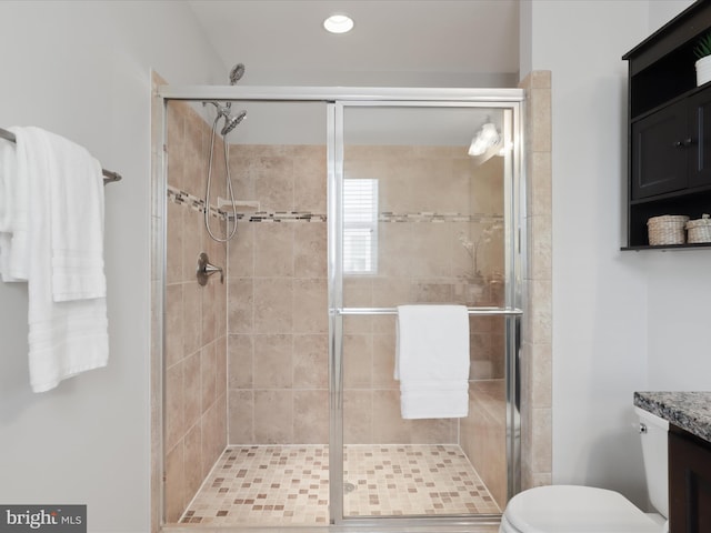 bathroom with toilet, a shower with shower door, and vanity