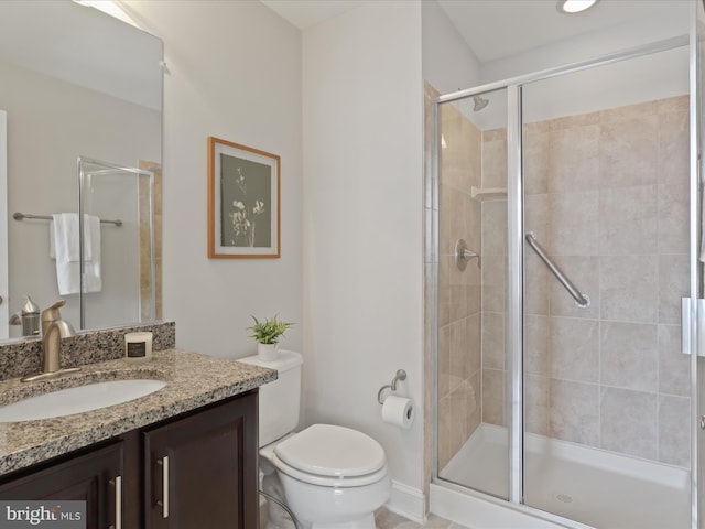 bathroom featuring toilet, an enclosed shower, and vanity