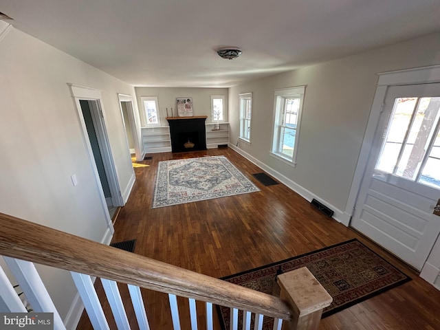 foyer with a wealth of natural light and dark hardwood / wood-style flooring