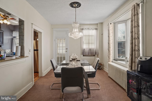 dining room featuring radiator, a notable chandelier, a textured ceiling, and carpet