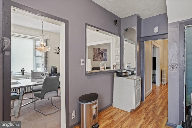 interior space featuring radiator, a notable chandelier, and light wood-type flooring