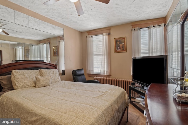 bedroom featuring radiator, a textured ceiling, and ceiling fan