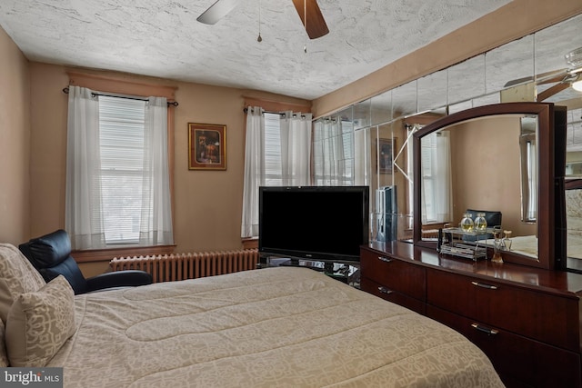 bedroom featuring ceiling fan, radiator, and a textured ceiling