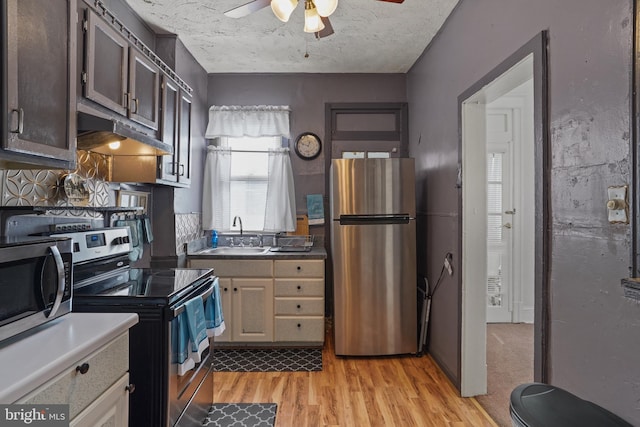 kitchen featuring sink, a textured ceiling, light hardwood / wood-style flooring, appliances with stainless steel finishes, and ceiling fan