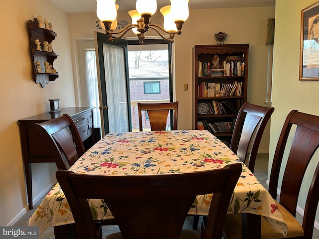 dining area featuring baseboards, carpet, and an inviting chandelier