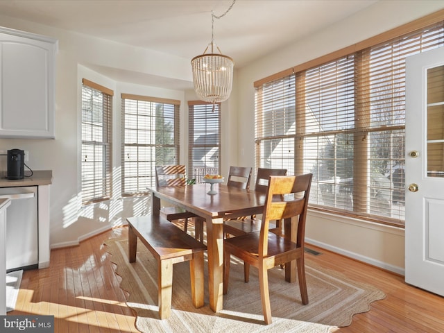 dining area featuring a notable chandelier and light wood-type flooring