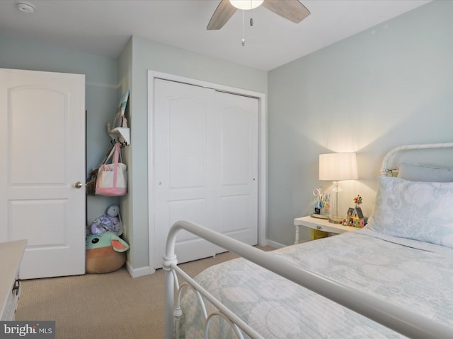 bedroom with light colored carpet, ceiling fan, and a closet