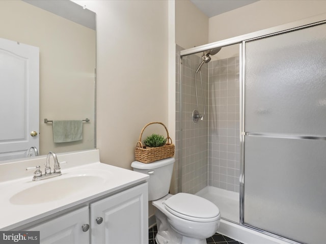 bathroom with vanity, a shower with door, and toilet