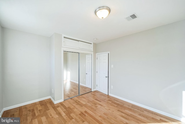 unfurnished bedroom featuring a closet and light hardwood / wood-style floors