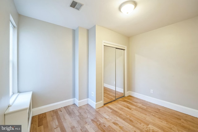 unfurnished bedroom featuring light wood-type flooring and a closet