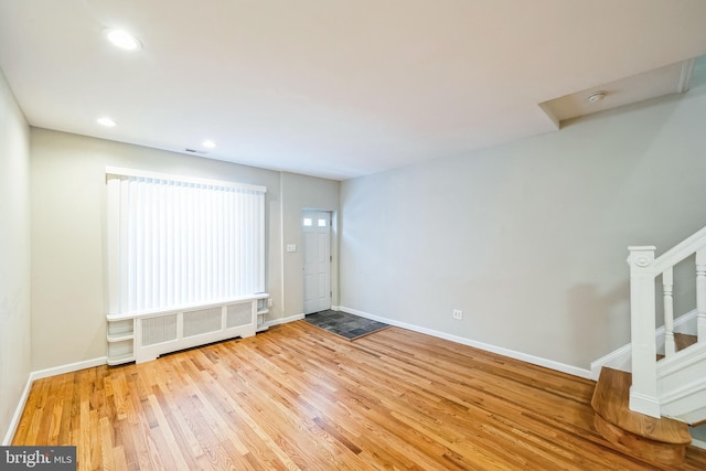 spare room with radiator and light hardwood / wood-style flooring