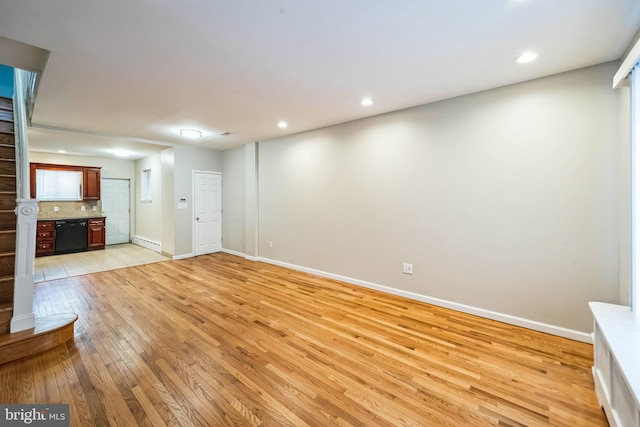 unfurnished living room with light wood-type flooring and a baseboard heating unit