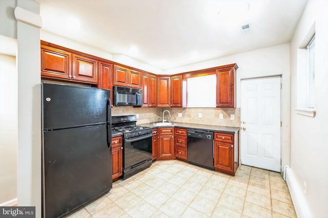 kitchen with black appliances, backsplash, sink, and baseboard heating