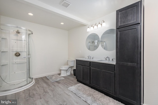 bathroom featuring vanity, toilet, hardwood / wood-style flooring, and a shower with door