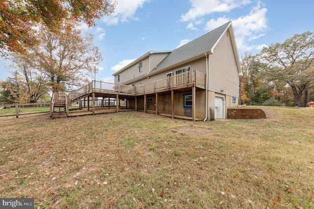 back of house with a garage, a deck, and a lawn