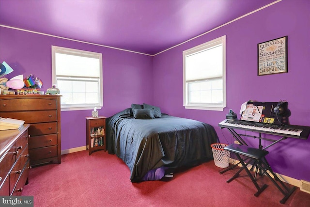 bedroom with light colored carpet and multiple windows