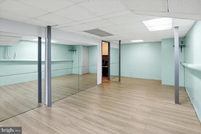 basement with light hardwood / wood-style floors and a drop ceiling