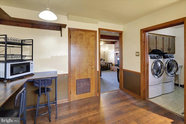 kitchen with separate washer and dryer, hanging light fixtures, and dark hardwood / wood-style flooring