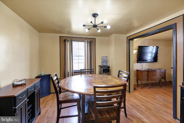 dining area featuring a notable chandelier and light wood-type flooring