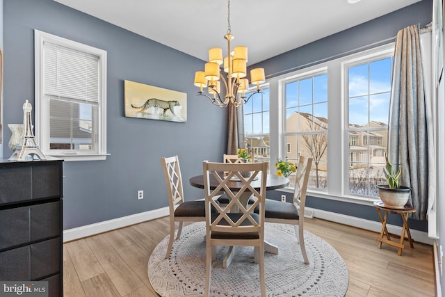 dining room with a notable chandelier and light wood-type flooring