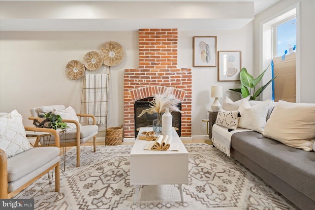 living room with light wood-type flooring and a brick fireplace