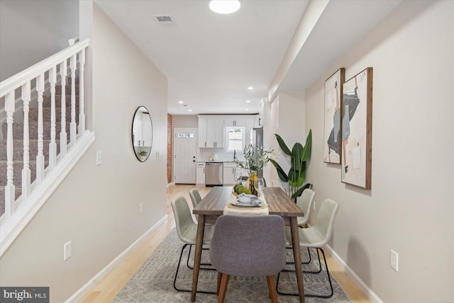 dining area with light wood-type flooring and sink