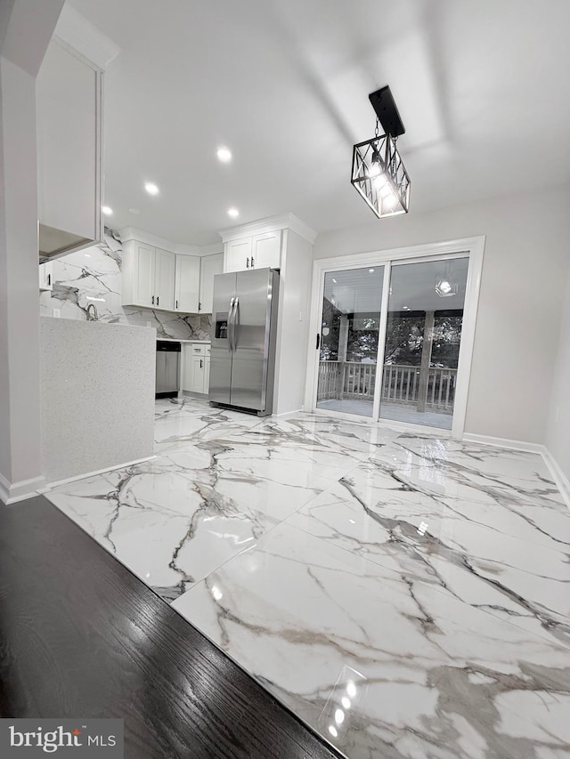 kitchen featuring light stone countertops, appliances with stainless steel finishes, pendant lighting, and white cabinets