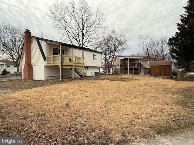 rear view of house with cooling unit and a lawn