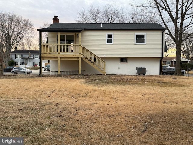 rear view of house featuring a lawn and central air condition unit