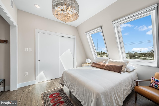 bedroom with wood-type flooring and a notable chandelier