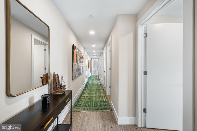 hallway with light hardwood / wood-style floors