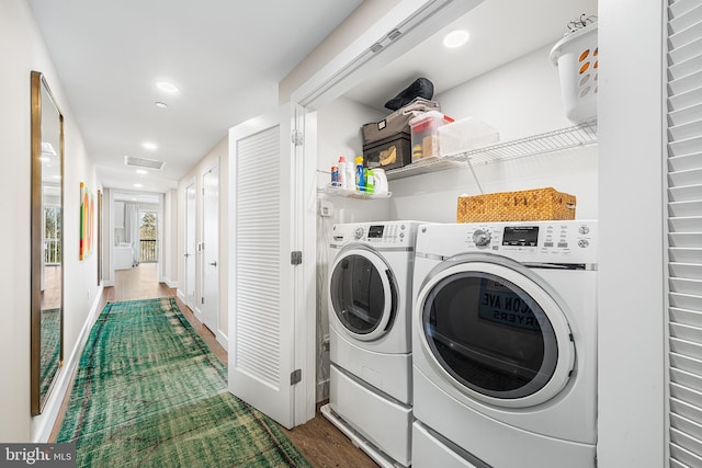 clothes washing area with hardwood / wood-style flooring and washing machine and clothes dryer