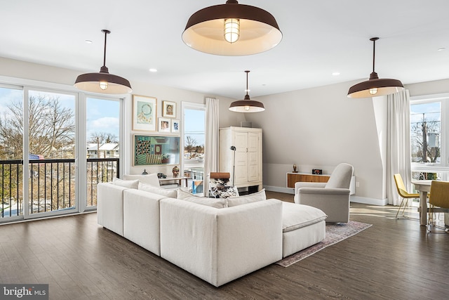 living room featuring dark wood-type flooring and a wealth of natural light