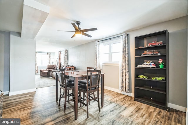 dining area with ceiling fan and wood-type flooring