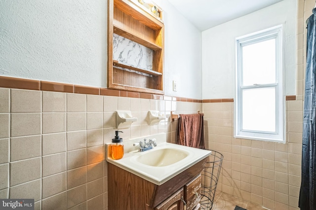 bathroom with vanity and tile walls