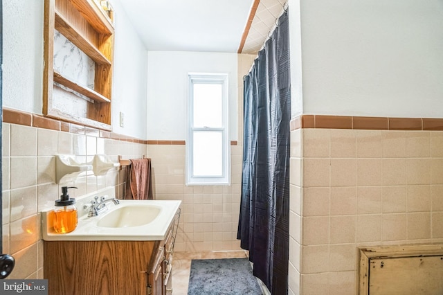 bathroom with tile patterned flooring, vanity, and tile walls