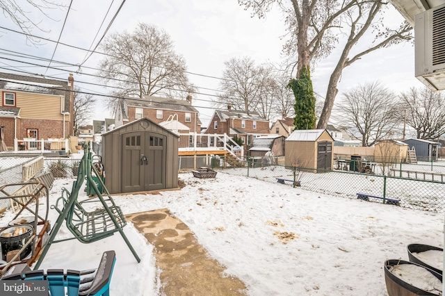 yard covered in snow featuring a shed