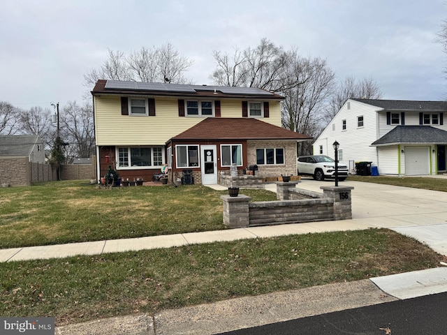 view of front of property featuring a front yard and solar panels