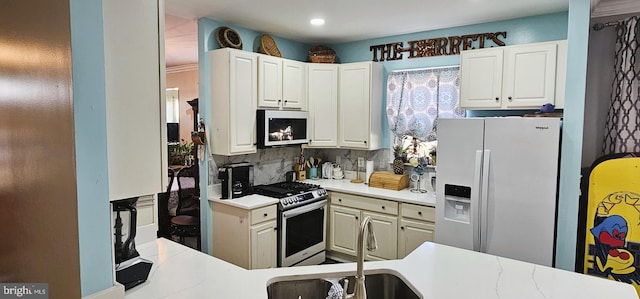 kitchen featuring a sink, tasteful backsplash, white fridge with ice dispenser, light countertops, and stainless steel range with gas stovetop