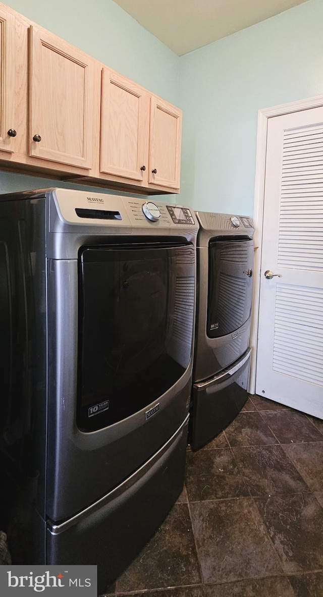 washroom with cabinet space and washer and clothes dryer