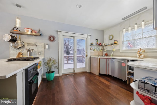 kitchen featuring pendant lighting, a wealth of natural light, dark wood-type flooring, and appliances with stainless steel finishes