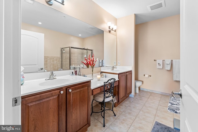 bathroom featuring tile patterned flooring, vanity, a shower with shower door, and toilet