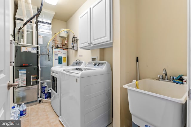 clothes washing area with sink, water heater, cabinets, washer and dryer, and light tile patterned flooring