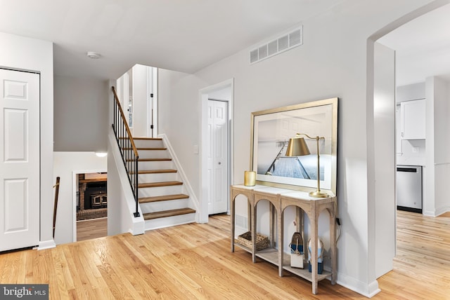 stairway featuring hardwood / wood-style flooring and a fireplace