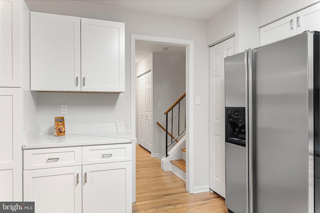 kitchen featuring white cabinetry, stainless steel fridge, and light hardwood / wood-style flooring