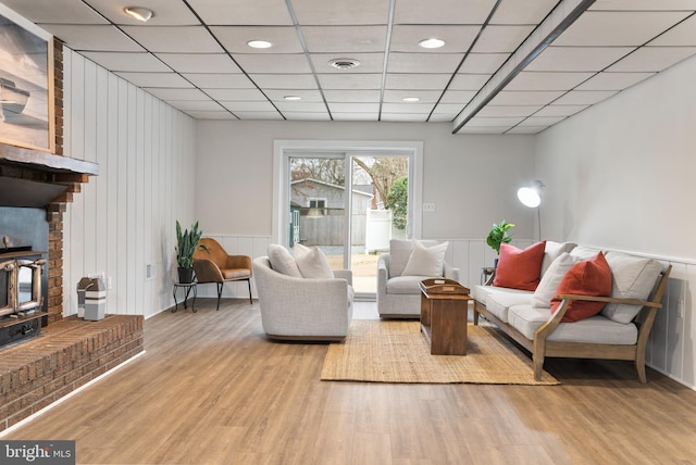 living room featuring a paneled ceiling and light wood-type flooring