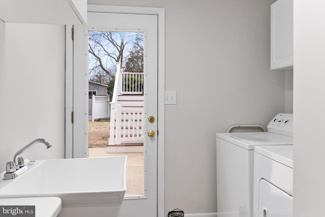 washroom featuring cabinets, sink, and washing machine and dryer