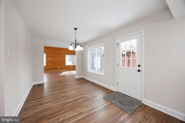 entrance foyer featuring dark hardwood / wood-style flooring and a notable chandelier