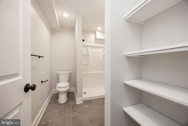 bathroom featuring walk in shower and toilet