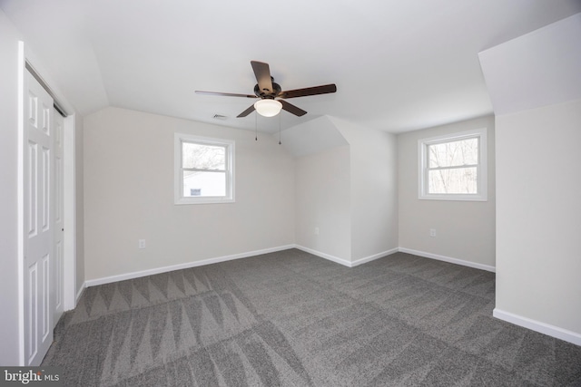 bonus room with lofted ceiling and dark carpet